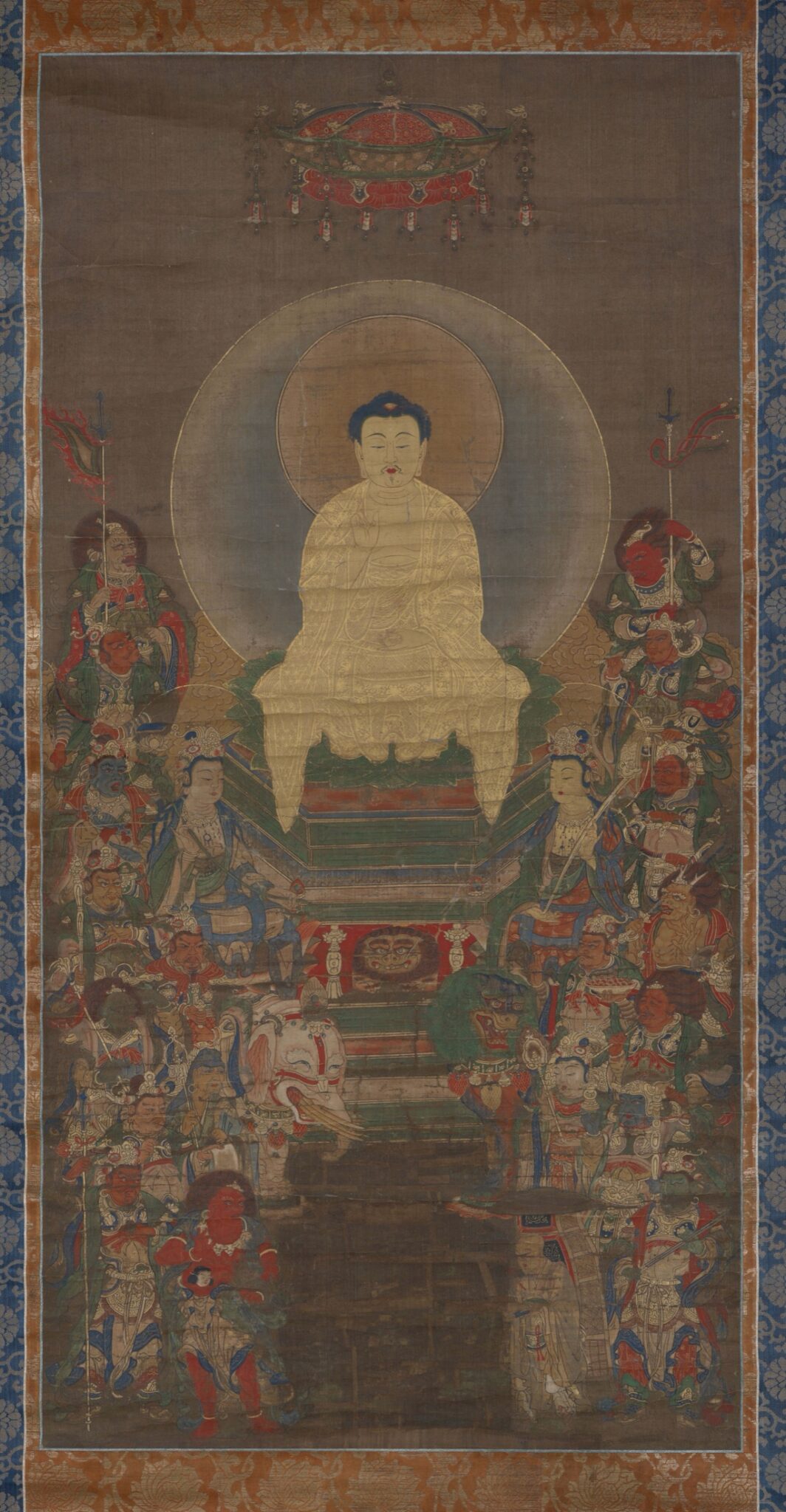 Shakyamuni seated beneath a jeweled canopy, surrounded by guardian deities and attendants in a Japanese Buddhist painting — TK0272