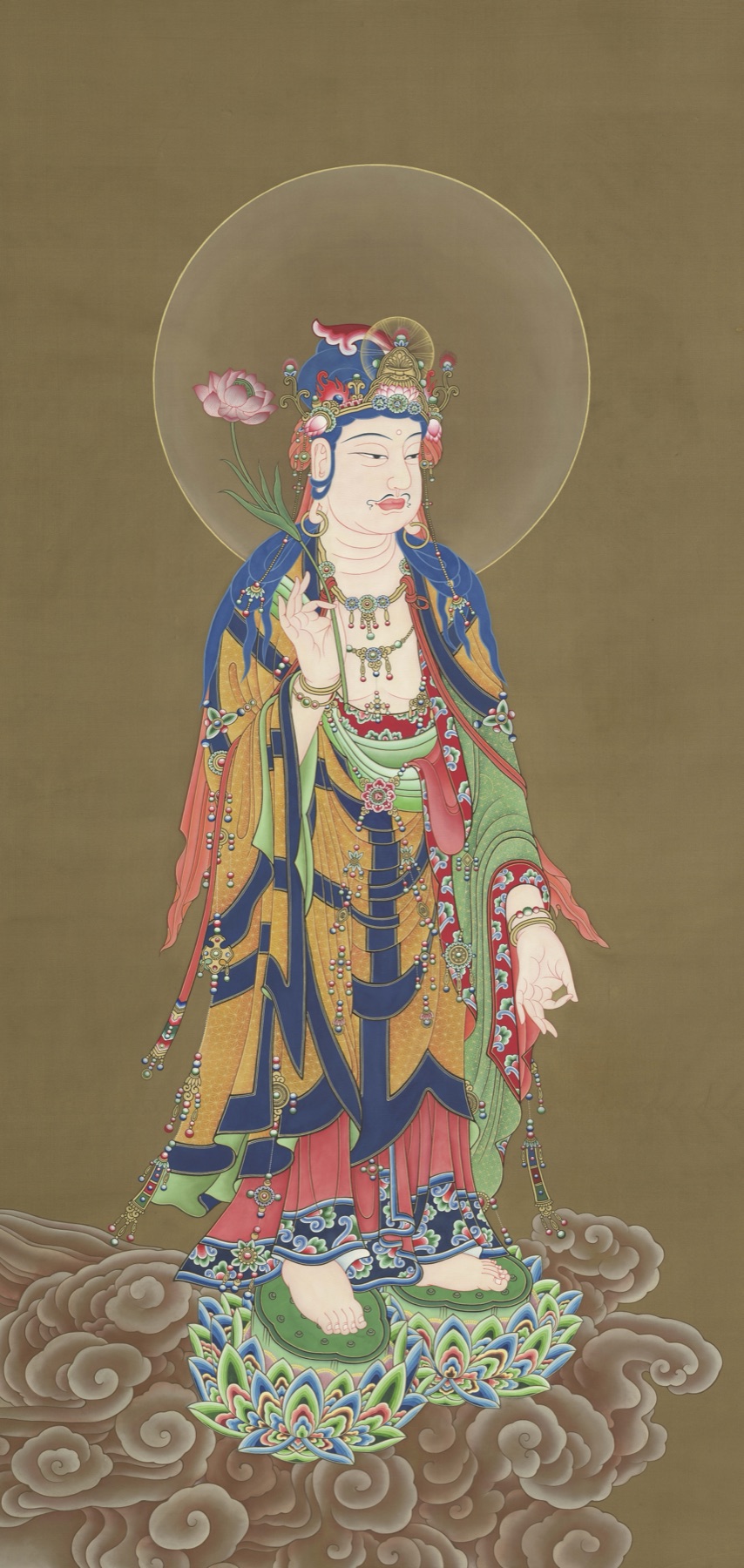 TK1106, a haloed standing Buddhist figure in layered blue, green, red, and gold garments with hanging jewelry, above a lotus-and-cloud base.
